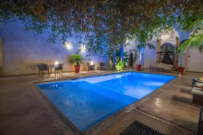 a swimming pool in the middle of a yard at Riad Charaï in Marrakech