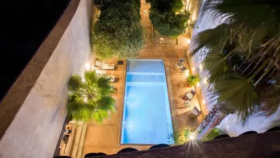 an overhead view of a swimming pool with palm trees at Riad Charaï in Marrakech