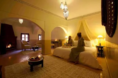 a man and woman sitting on a bed in a bedroom at Riad Charaï in Marrakech