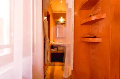 a hallway with a bathroom with a sink and a mirror at Riad Mazaya in Marrakech