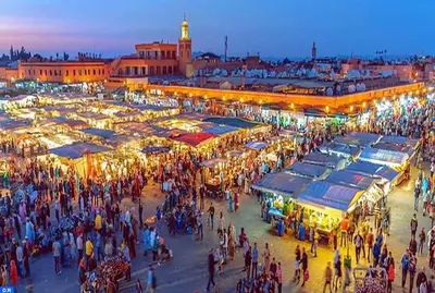 a crowd of people walking around a market at night at Villa avec piscine a Marrakech in Marrakech