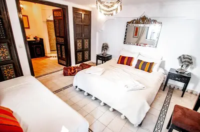 a bedroom with two beds and a mirror at Riad Makila in Marrakech