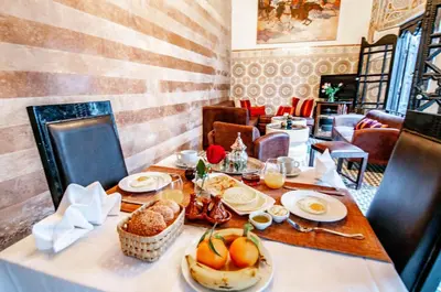 a table with food on it in a restaurant at Riad Makila in Marrakech