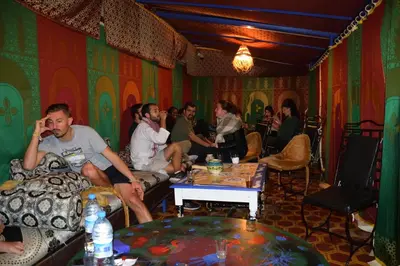 a group of people sitting in a room talking on cell phones at For You Riad Marrakech in Marrakech
