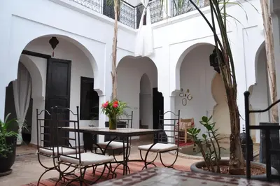 a courtyard with a table and chairs in a building at Riad Sin in Marrakech