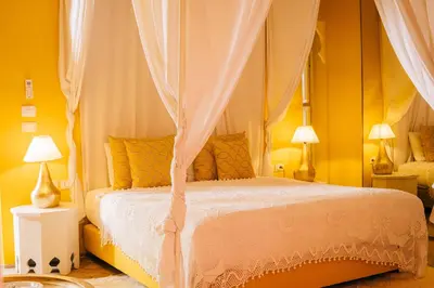 a bedroom with a canopy bed with yellow walls at Riad Nashira & Spa in Marrakech