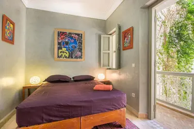 a bedroom with a bed with purple sheets and a window at Riad Privé De Luxe Au Coeur De La Kasbah Avec Hammam in Marrakech