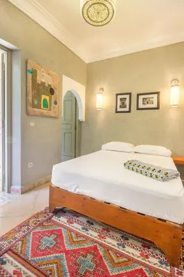 a bedroom with a large bed with a rug at Riad Privé De Luxe Au Coeur De La Kasbah Avec Hammam in Marrakech