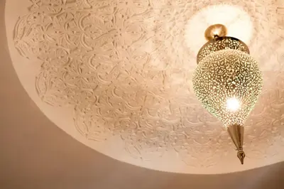 a light fixture on a ceiling with a flower pattern at Riad Alkaderi in Marrakech