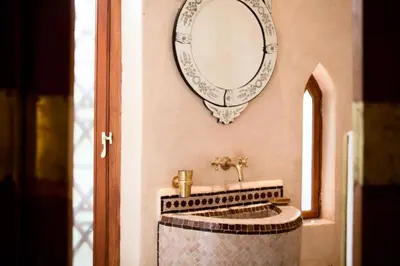 a bathroom with a sink and a mirror on the wall at Riad Alkaderi in Marrakech