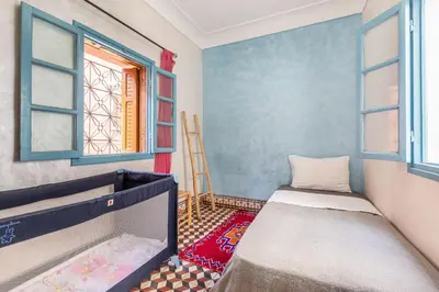 a small room with a bed and two windows at Exclusive private Riad in Marrakech