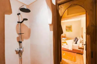 a person standing in a bedroom looking into a room at Riad Berenssi in Marrakech