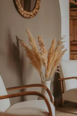 a vase filled with tall grass next to a mirror at Riad Sierra in Marrakech