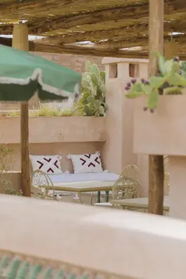 a patio with a table and chairs and a cactus at Riad Sierra in Marrakech