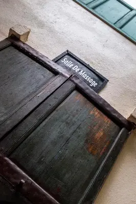 a wooden door with a sign on the side of a building at Riad Le Coq Berbère in Marrakech