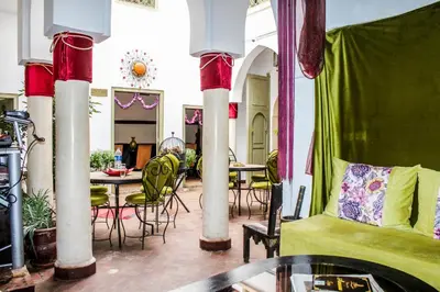 a living room with tables and chairs and a couch at Riad Minorisa in Marrakech