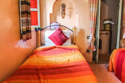 a bedroom with a bed with a colorful blanket at Riad Minorisa in Marrakech