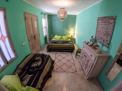 two beds in a room with green walls at Riad Tahani in Marrakech