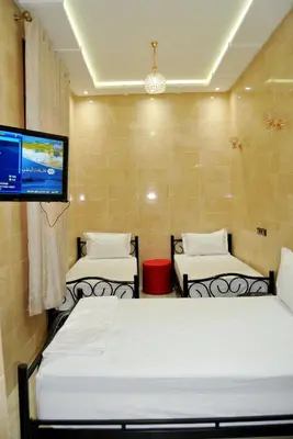 a room with two beds and a flat screen tv at Résidence Miramare Marrakech in Marrakech
