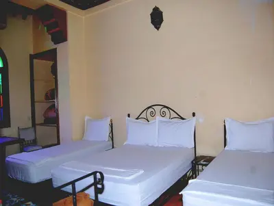 two beds in a room with white sheets and pillows at Résidence Miramare Marrakech in Marrakech
