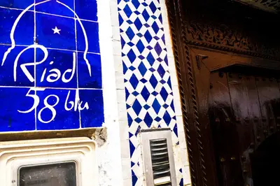 a blue and white wall with a sign on it at Riad 58 Blu in Marrakech