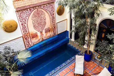 a building with a blue bench with a decorative window at Riad 58 Blu in Marrakech