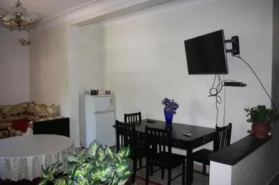 a living room with a table and a television on the wall at Rue Riad Zitoun el Jdid in Marrakech