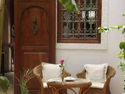 a room with a table and chairs and a door at Riad Les Bougainvilliers in Marrakech