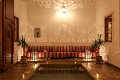 a living room with a red couch in a wall at Riad Les Bougainvilliers in Marrakech