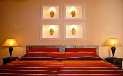 a bedroom with a bed with three pictures on the wall at Riad Rabahsadia in Marrakech