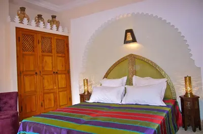 a bedroom with a large bed with a colorful blanket at Riad Rabahsadia in Marrakech