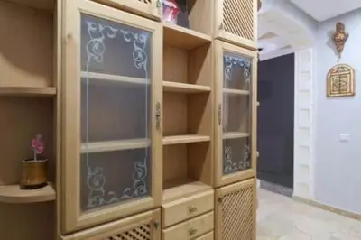 a large closet with glass doors and shelves at Studio au centre wifi Clim in Marrakech
