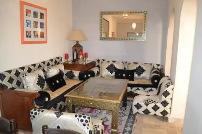 a living room with couches and a table and a mirror at Riad Bayti in Marrakech