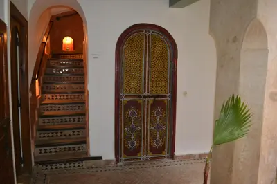 an entrance to a building with a wooden door and stairs at Riad Bayti in Marrakech
