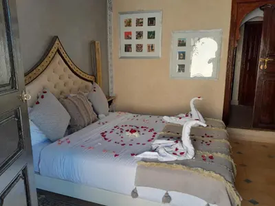 a bedroom with a bed with swans on it at Riad Bayti in Marrakech