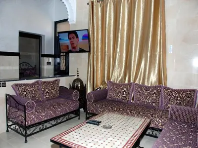 a living room with purple couches and a tv at Appartements Ziad Guéliz in Marrakech