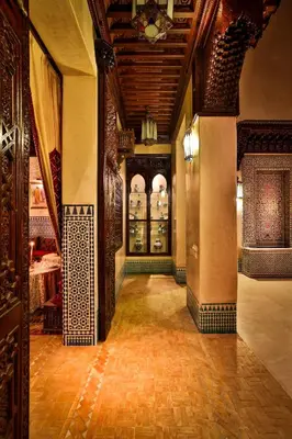 a hallway of a building with a room with glass doors at Riad Kniza in Marrakech