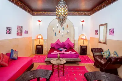 a bedroom with a bed and a rock wall at Riad Dar Nadwa in Marrakech