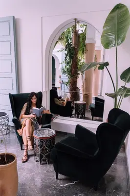 a woman sitting in a chair in a living room at Riad Albatoul in Marrakech