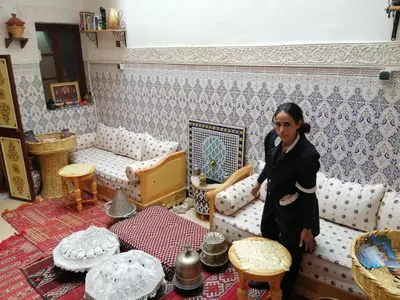 a woman standing in a living room with a couch at Dar Margot Marrakech in Marrakech