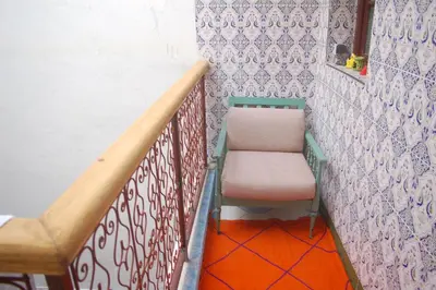 a stairway with a pink chair sitting on a wall at Dar Margot Marrakech in Marrakech