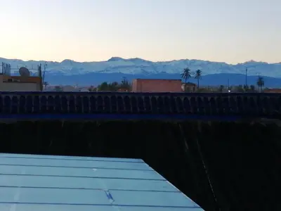a view of the mountains from a roof of a building at Dar Margot Marrakech in Marrakech