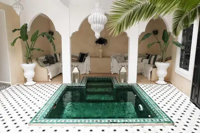 a living room with a pool in the middle of a house at Riad SHIRAZ in Marrakech