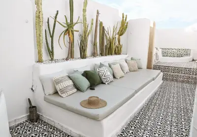 a white couch with pillows and plants on it at Riad SHIRAZ in Marrakech