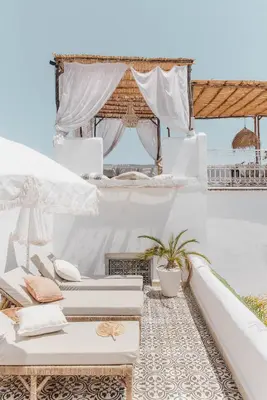 a white room with white furniture and a table at Riad SHIRAZ in Marrakech