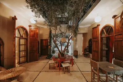 a living room with a table and a tree in it at Dar Nour el Houda in Marrakech