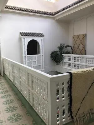 a white railing with a dog house on the wall at EDEN KAM Riad in Marrakech