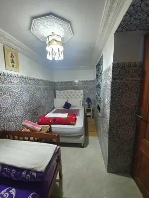 a bedroom with two beds and a chandelier at Riad 112 in Marrakech
