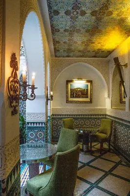 a room with a table and chairs and a painting on the ceiling at Elegancia Riad Boutique & SPA in Marrakech