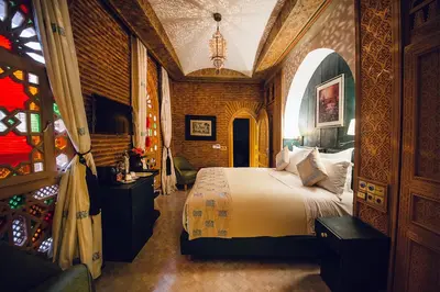 a bedroom with a bed and a stained glass window at Elegancia Riad Boutique & SPA in Marrakech